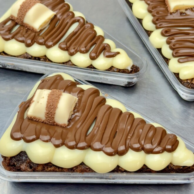Fatia de pizza brownie chocolatuda muito recheada com brigadeiro ninho, nutella e kinder bueno. Peça agora mesmo a sua! Peso médio de 140g.