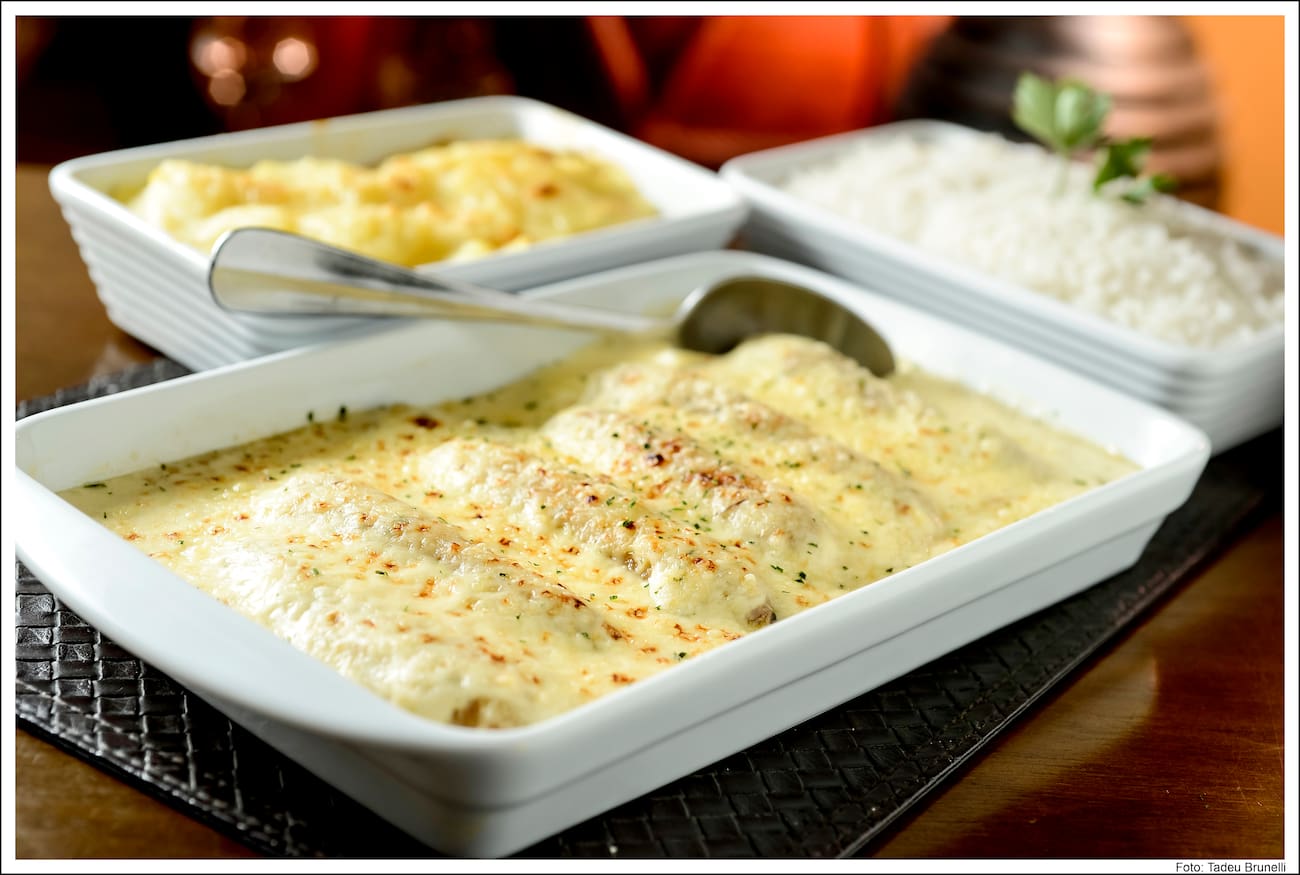 Tradicional nas famílias cearenses. Perfeita combinação de filé de peixe com bananas fritas e molho à base de creme de leite. Acompanha arroz branco e batatas gratinadas