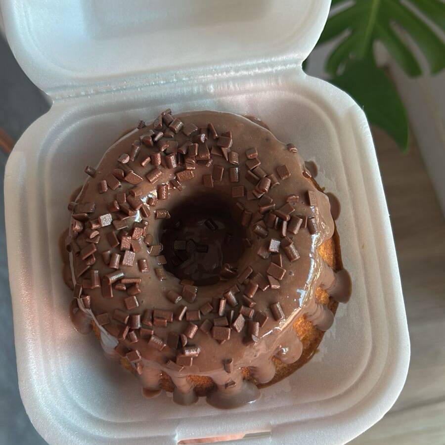 bolo de chocolate com cobertura de chocolate e granulado por cima.