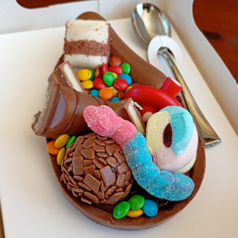 Deixe sua criança ainda mais feliz com esse delicioso ovo de colher, preparado com casca de chocolate nobre, deliciosamente recheado com nosso cremoso brigadeiro gourmet, finalizado com diversas guloseimas, brigadeiro, fini, confetes, marshmallow, Kinder Bueno, Kinder chocolate.