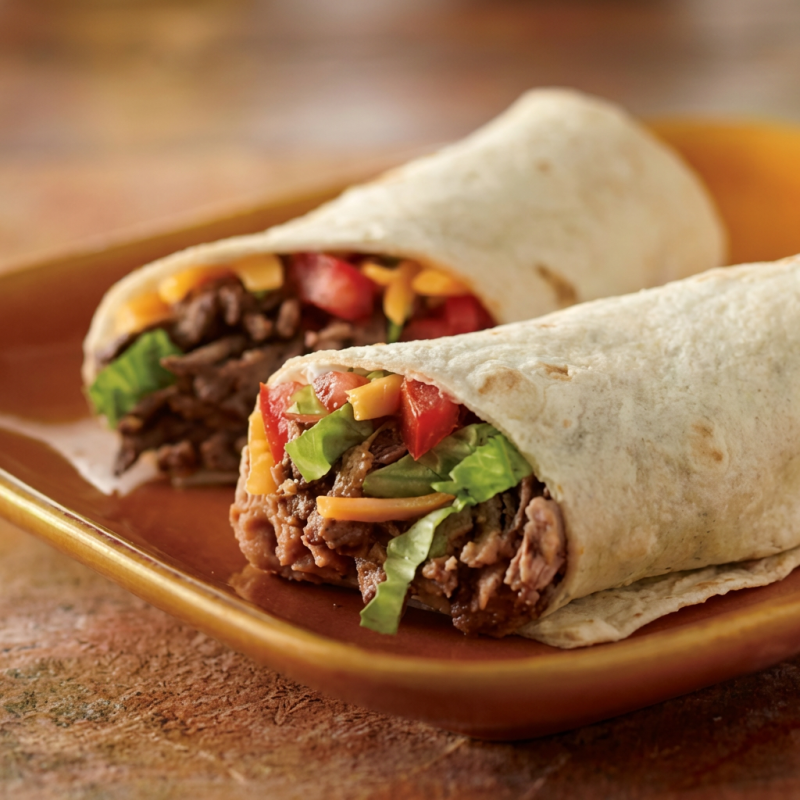 Tortilla recheada com frijoles, carne vegetal, alface, tomate e sour cream e pimenta sriracha. Obs: Frijoles picante pois vai pimenta sriracha no preparo, não sendo possível retirar a mesma. Para adicionar mais pimentas, selecione no campo complementos. Para pedir molhos ou pimentas a parte, selecione também o item ""embalagem extra"""Atenção: NÃO TEM COMO RETIRAR COENTRO, CEBOLA E ALHO Peso médio:190g