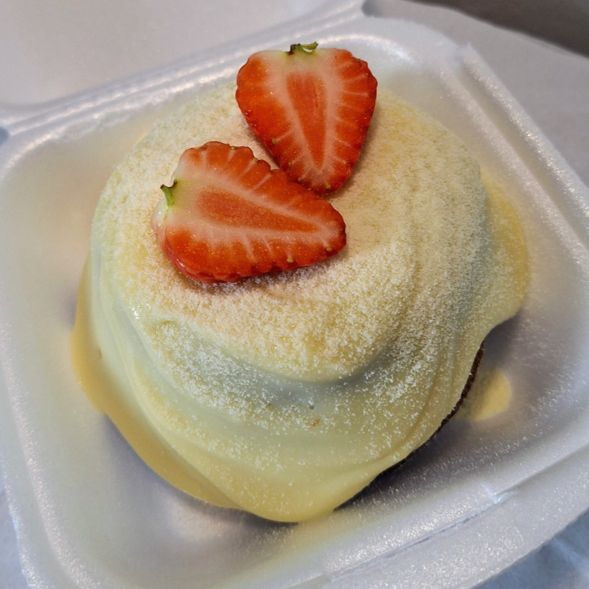 Massa de chocolate, coberto com brigadeiro cremoso de leite ninho e morangos frescos. Enviado em uma lancheira de hambúrguer.