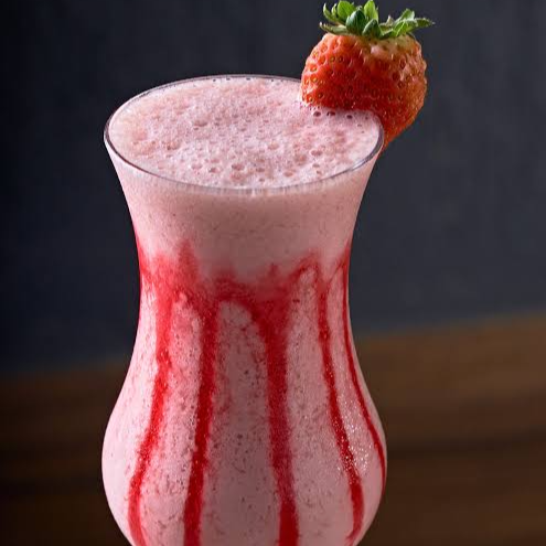 Caipifruta de morango batida com morango e leite Moça. Com Vodka.