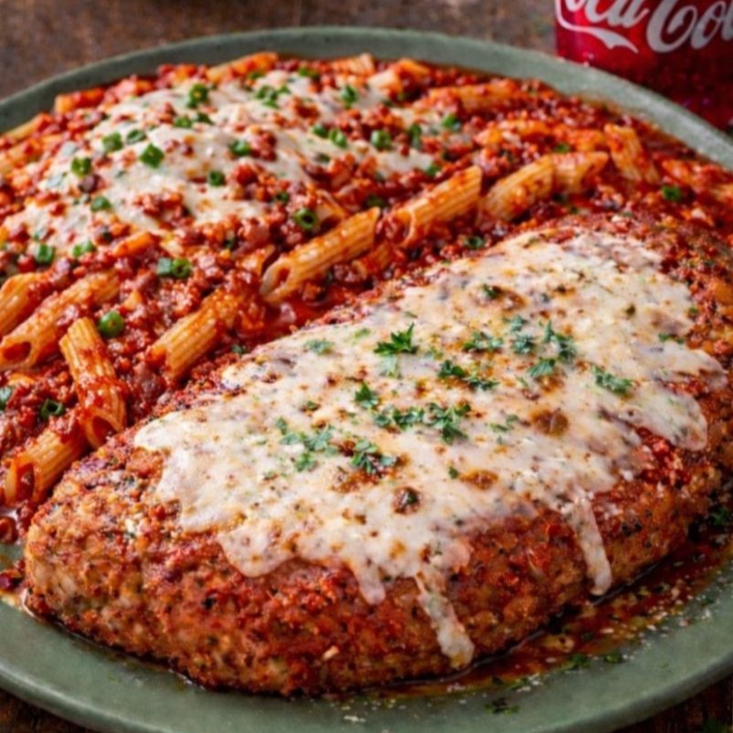 Uma suculenta Parmegiana de frango, empanada no ponto perfeito, coberta com um molho de tomate artesanal e generosas camadas de queijo derretido. Acompanhada de um macarrão à bolonhesa cremoso e bem temperado, o prato é finalizado com ainda mais queijo e um toque fresco de cebolinha, trazendo aroma, cor e sabor irresistíveis. Uma explosão de conforto e sabor em cada garfada.