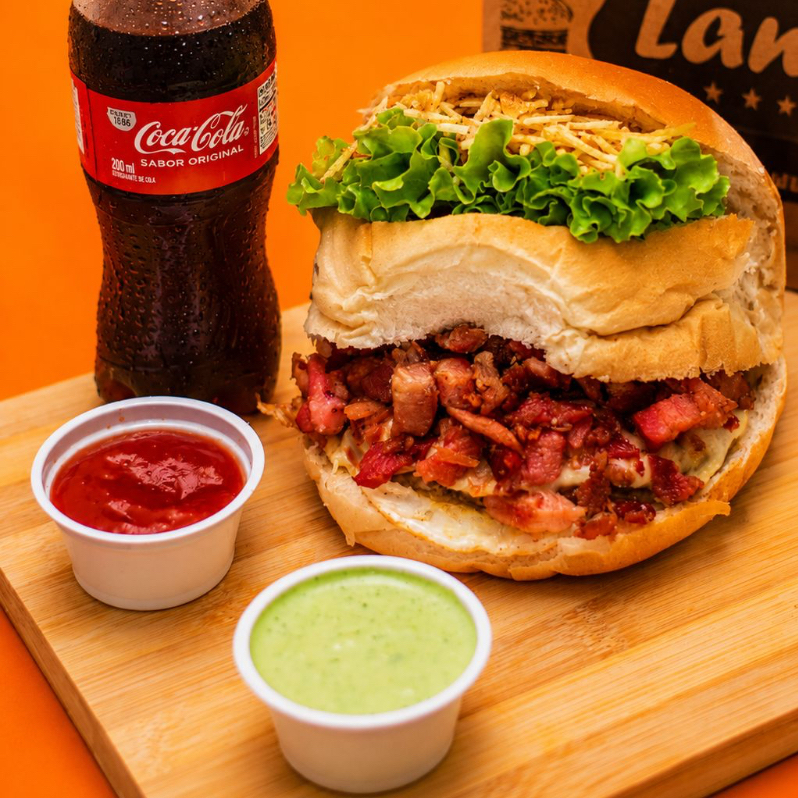 Combo x-egg bacon — perigoso de tão saboroso! Pão macio com carne suculenta, ovo, bacon crocante, queijo, salada fresquinha e batata palha pra dar aquele toque especial Coca-Cola 200ml bem gelada pra acompanhar