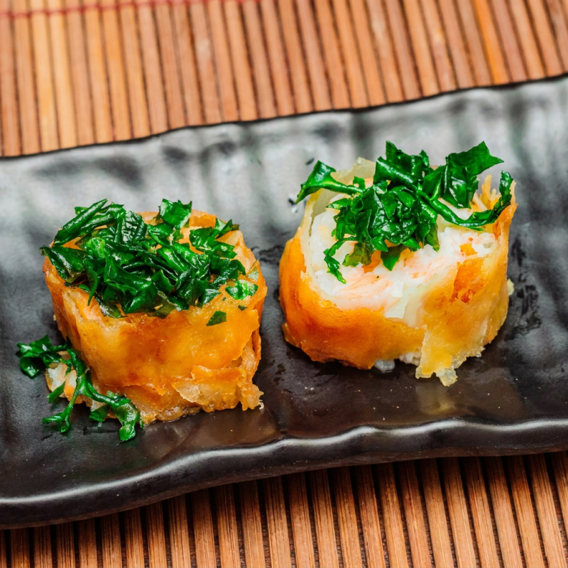 Salmão, kani, gergelim, cebolinha e arroz japonês, envoltos em cream cheese na massa de harumaki e finalizada com crispy de couve