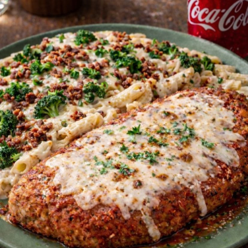 Uma deliciosa Parmegiana de Frango acompanhada de um macarrão de brócolis ao molho branco cremoso, enriquecido com bacon crocante que dá aquele toque especial de sabor. Finalizado com queijo derretido e cebolinha fresca, esse prato entrega suculência, textura e uma explosão de aroma que conquista no primeiro garfo. Uma combinação farta, deliciosa e irresistível!