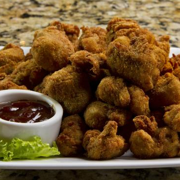 Deliciosa porção de filé mignon empanado, acompanhado de molho especial como cortesia