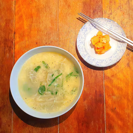 É um prato presente nas comemorações de início de ano da cultura coreana. Uma agradável combinação de caldo de carne bovina e tteok, massa branca feita à base de arroz, que, fatiada em formato similar às antigas moedas coreanas, representa tanto a limpeza espiritual quanto a prosperidade desejadas em início de novos ciclos de vida. O caldo é acompanhado por 6 mandus, pastéis recheados com carne de