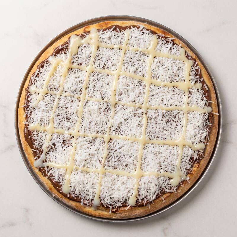 Feita com nossa massa artesanal doce, coberta com creme de leite cremoso, chocolate preto derretido, coco ralado e finalizada com um toque de leite condensado. A combinação do chocolate preto com o frescor do coco cria uma experiência única de sabores intensos e texturas contrastantes, enquanto o creme de leite e o leite condensado acrescentam uma cremosidade irresistível. (4 fatias