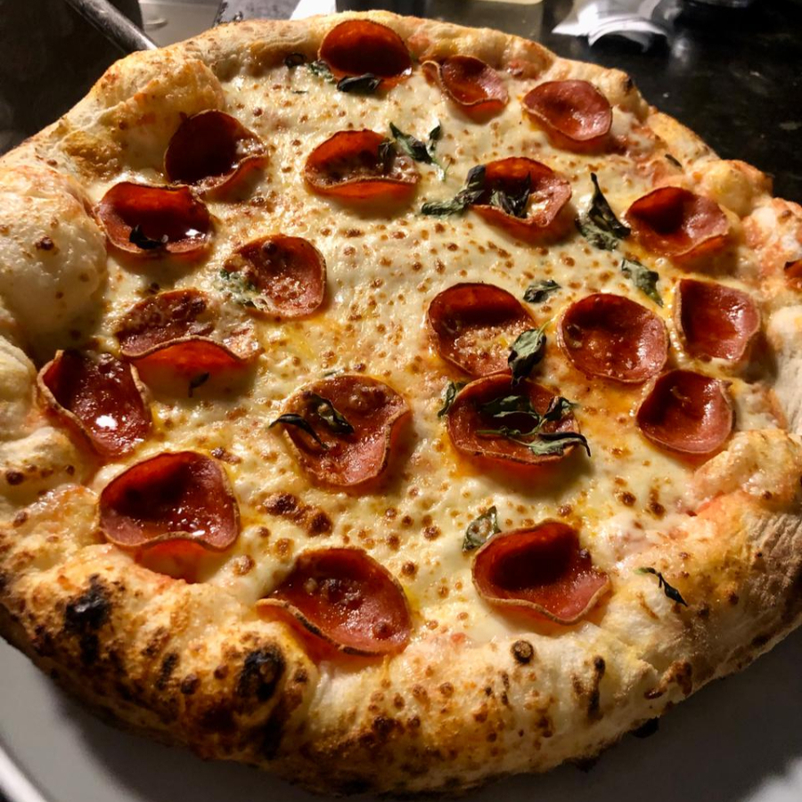 Molho de tomate, mussarela, fatias de peperone, manjericão e orégano.