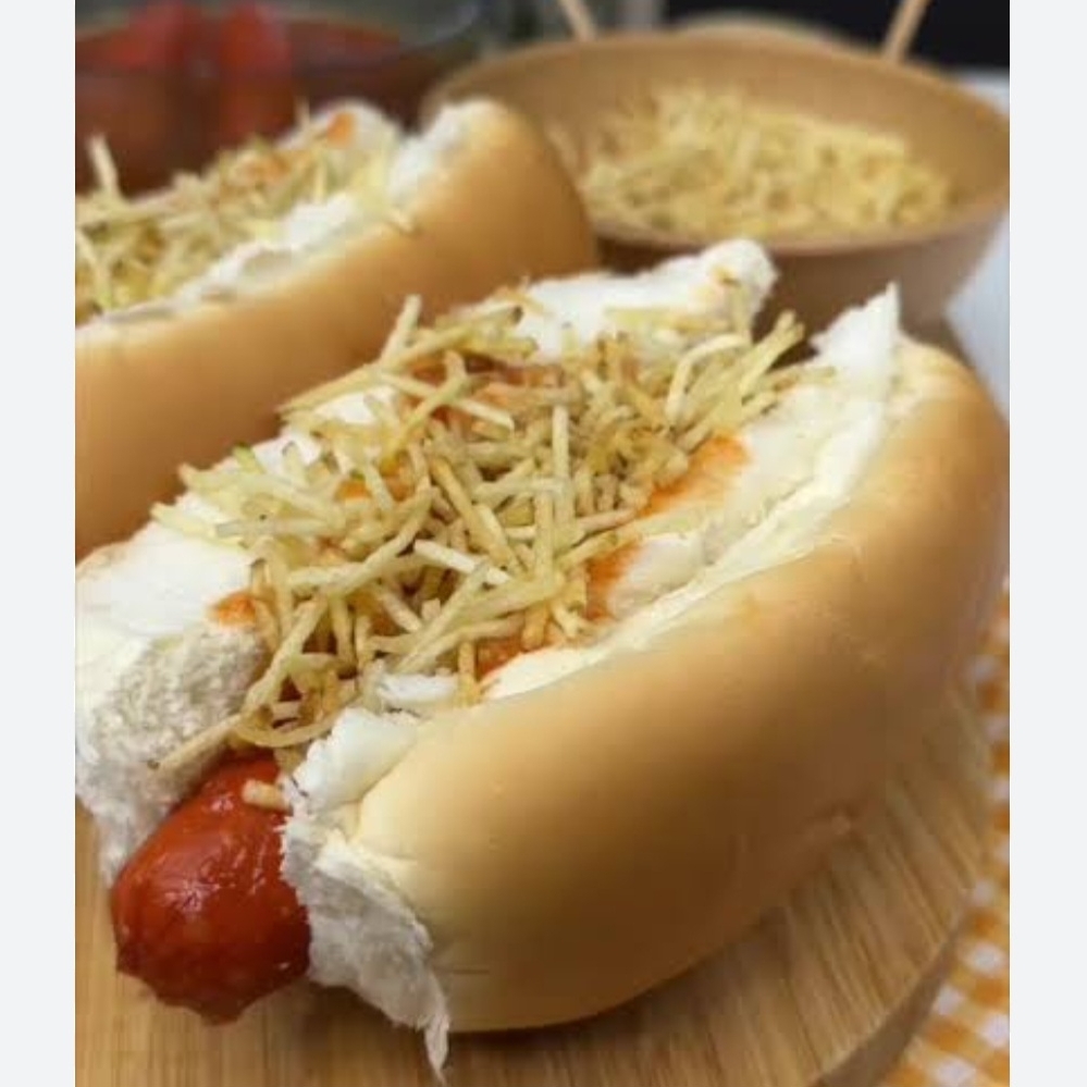 Pão macio de cachorro-quente, salsicha bem quentinha, ketchup no ponto, molho verde cremoso, milho soltinho, queijo ralado, ovo de codorna e uma camada generosa de batata palha crocante. Um hot dog completo, saboroso e feito pra matar a fome com estilo!