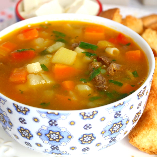 Duas sopas de carne, com pedaços de carne, macarrão parafuso e legumes. Acompanha duas porções de torradas.