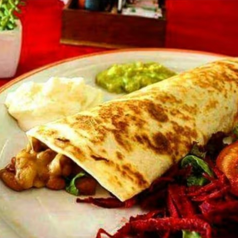 Tortilla de trigo recheada com queijo derretido, alface em tiras, tomate picado e feijão mexicano.