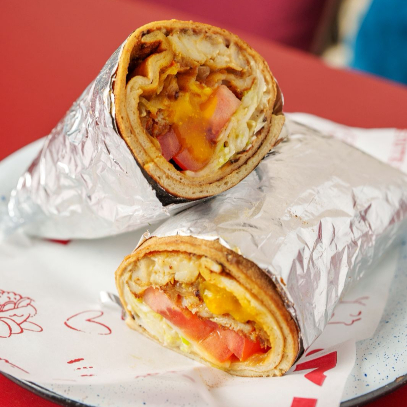 Peixe branco temperado com cebola na chapa, tehina, amba (a base de manga, curry e especiarias), repolho e tomate, servido na lafa.