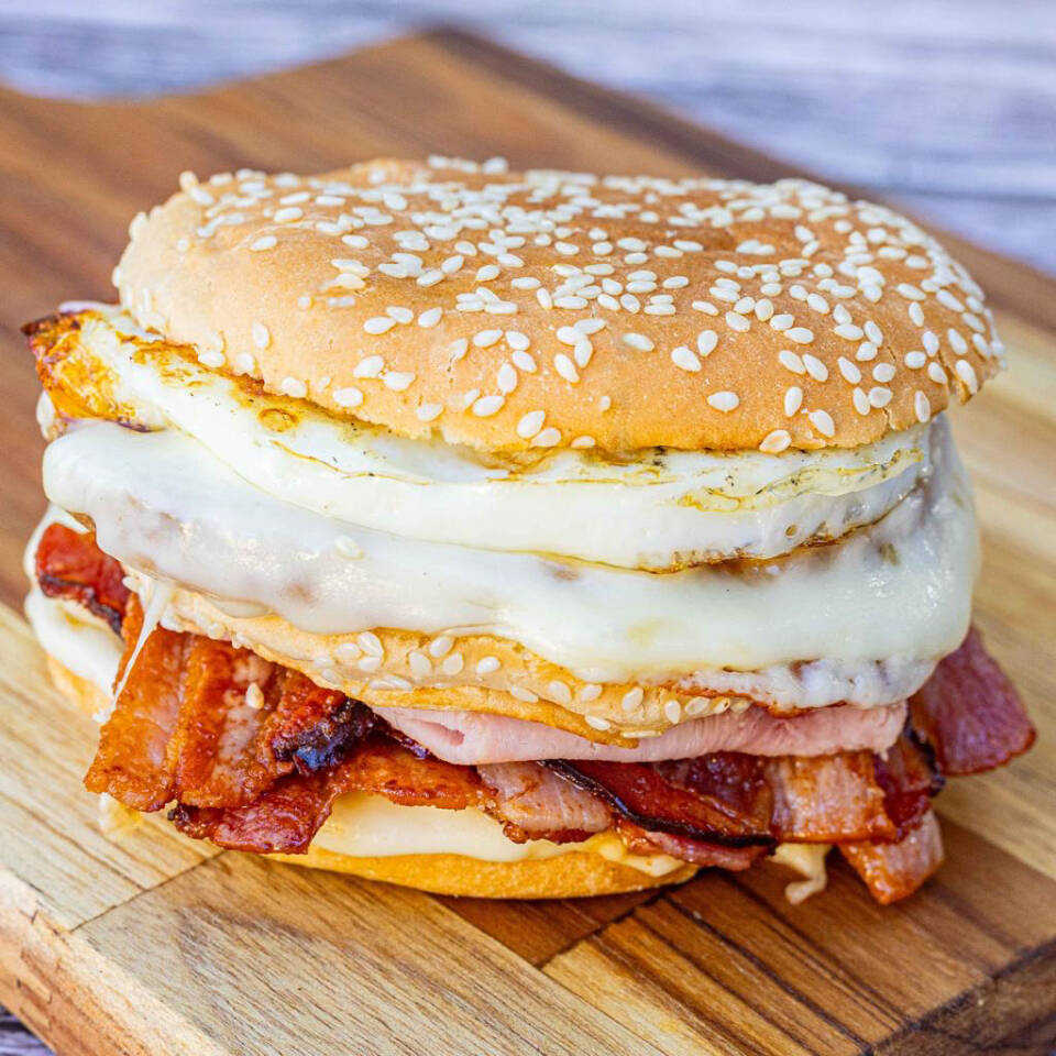 Pão macio, 2 hambúrgueres, 2 queijos, ovo, presunto e bacon.