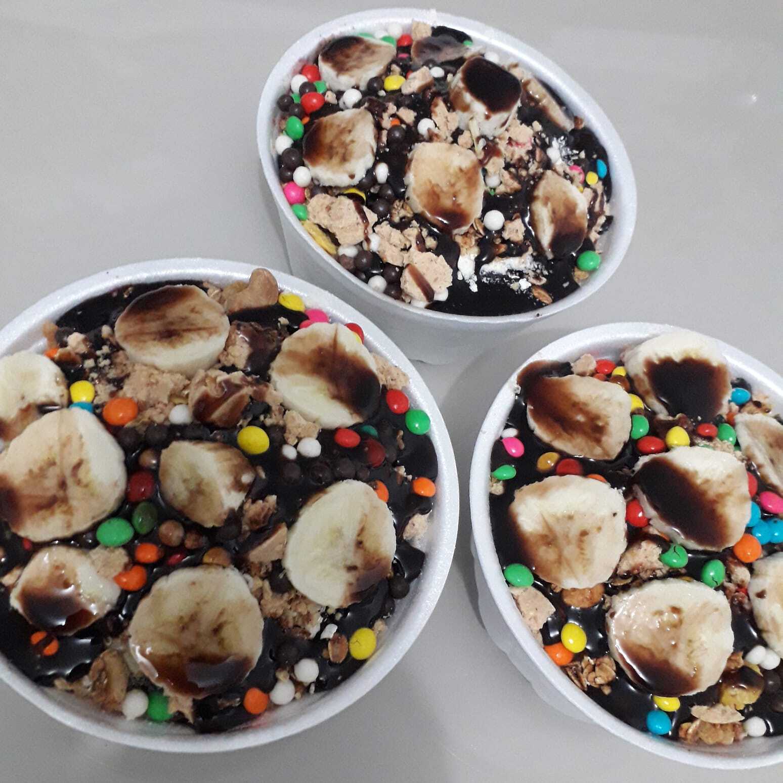 3 açai de 900ml, granola, leite em po, farinha de amendoim, paçoca, banana, uva e cobertura OBS: O PRODUTO É VENDIDO POR ML.