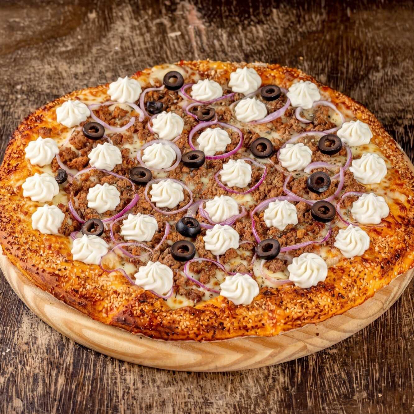 Molho da casa, mussarela, atum, cebola roxa, cream cheese, azeitona preta, orégano e gergelim na borda.