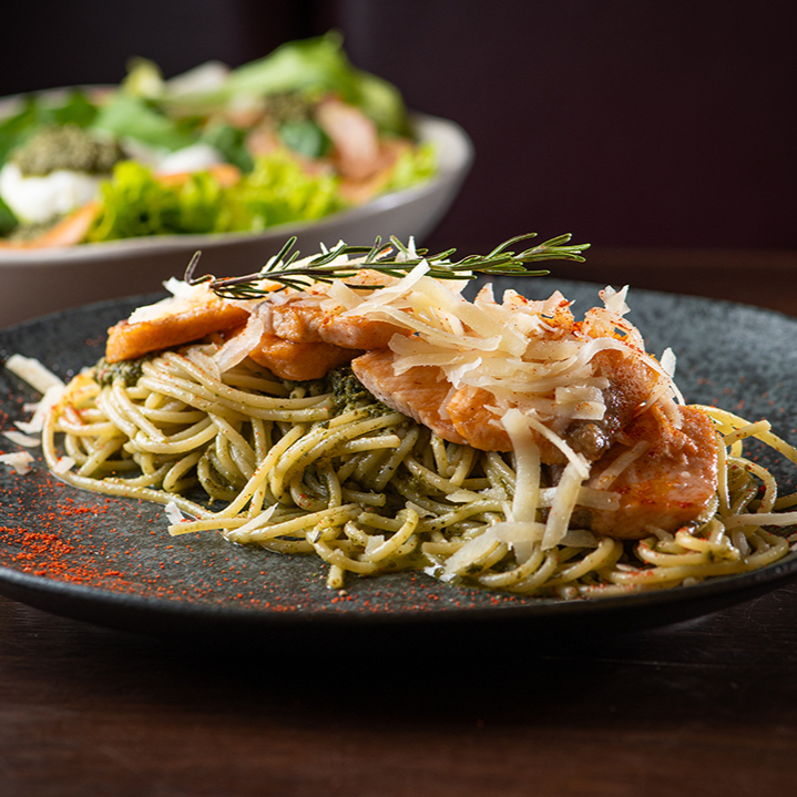 Spaghetti al dente com pesto, finalizado com lascas de salmão com toque de limão