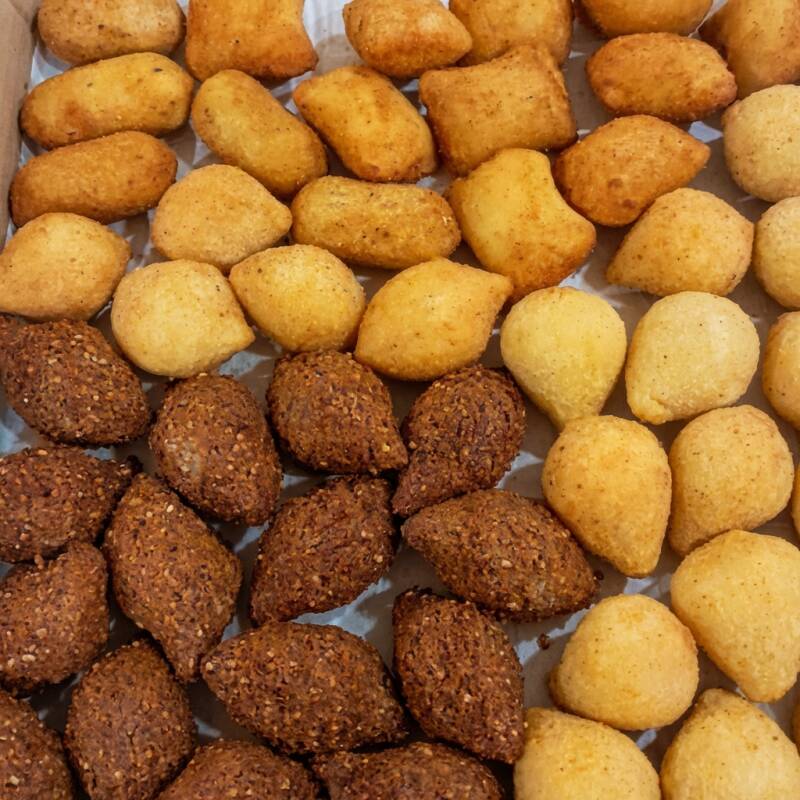 Nossos '50 Salgadinhos' (aproximadamente 20g cada), pertencentes à categoria 'Salgadinhos', são uma verdadeira explosão de sabores. Oferecemos uma variedade que inclui a irresistível coxinha de frango, o clássico enroladinho de salsicha, a suculenta almofadinha que reúne queijo e presunto em harmonia perfeita, o exótico kibe, o saboroso enroladinho de carne e o apetitoso enroladinho de calabresa. Não podemos esquecer da nossa bolinha de queijo, que é simplesmente divina. Cada um desses salgadinhos é preparado com ingredientes frescos e selecionados para garantir a máxima qualidade e sabor.
