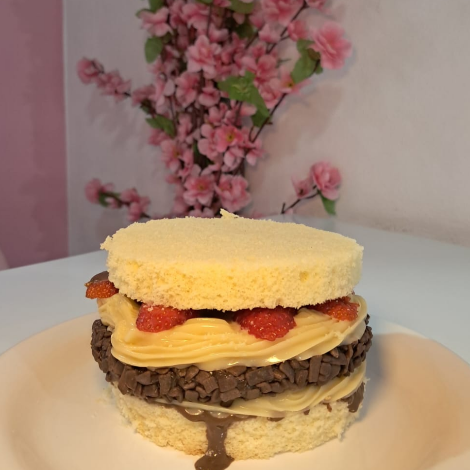 Um hambúrguer doce irresistível! Feito com pão de massa branca macio, hambúrguer de brigadeiro gourmet, brigadeiro de Ninho cremoso, morangos frescos e calda de chocolate. Uma sobremesa divertida, criativa e deliciosa que une o visual de um hambúrguer ao sabor dos seus doces favoritos