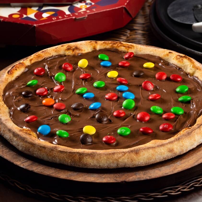 Feita com massa artesanal, Nutella Original e coberta com confeitos de M&M para tornar tudo mais crocante. Tamanho individual com 25cm e 4 fatias, ideal para quem quer adoçar o momento.