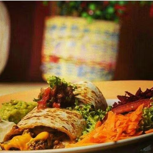 Tortilla de trigo recheada com queijo derretido, alface em tiras, tomate picado e feijão mexicano.