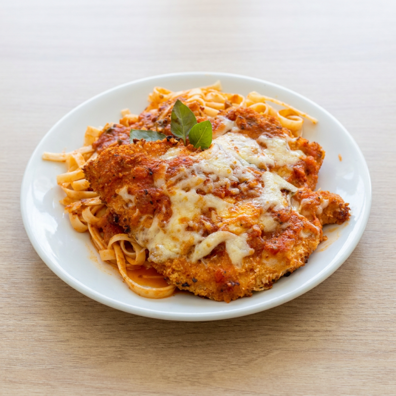 Delicie-se com nossa irresistível massa ao molho sugo, acompanhada de suculenta parmegiana de frango. Finalizada com um generoso toque de molho pomodoro e mussarela gratinada, é a combinação perfeita para um momento especial!