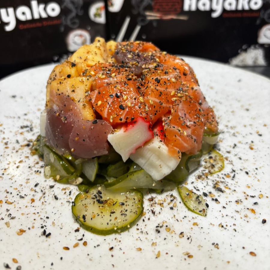 Saboreie o sunomono misto com salmão, kani, peixe branco, polvo e gergelim, uma mistura harmoniosa de ingredientes frescos e deliciosos.