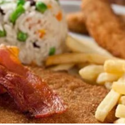 Delicioso frango empanado com arroz a grega, batata frita, bacon em fatias e banana a milanesa.