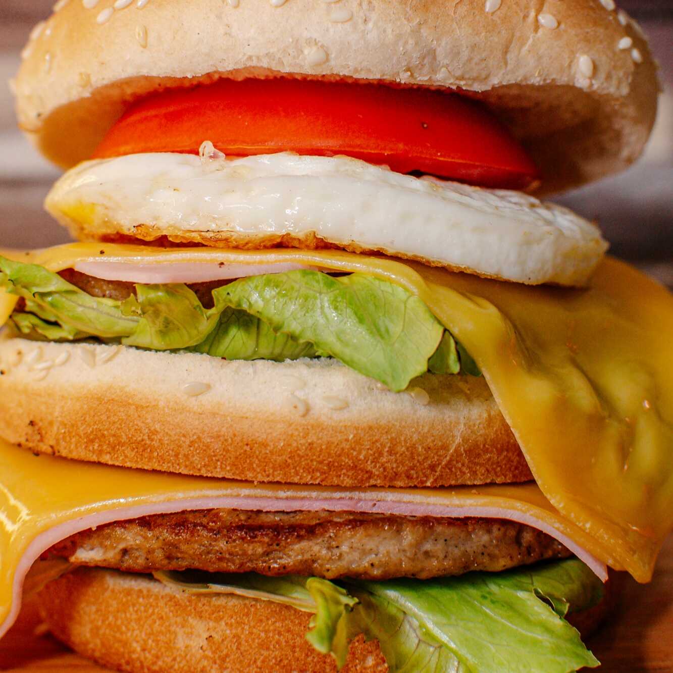 Pão duplo com gergelim, duas carnes bovina de 56g, presunto, queijo prato, ovo, alface americana e tomate