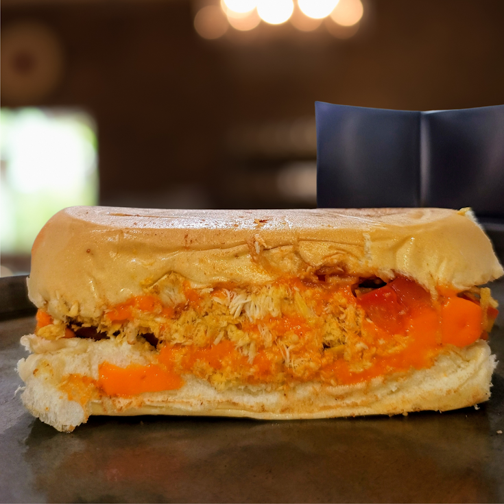 Uma combinação suculenta de frango e bacon, com pão, duas salsichas Perdigão, Mussarela, maionese artesanal, tomate, cebola, milho, ketchup, mostarda, Cheddar
e batata palha.