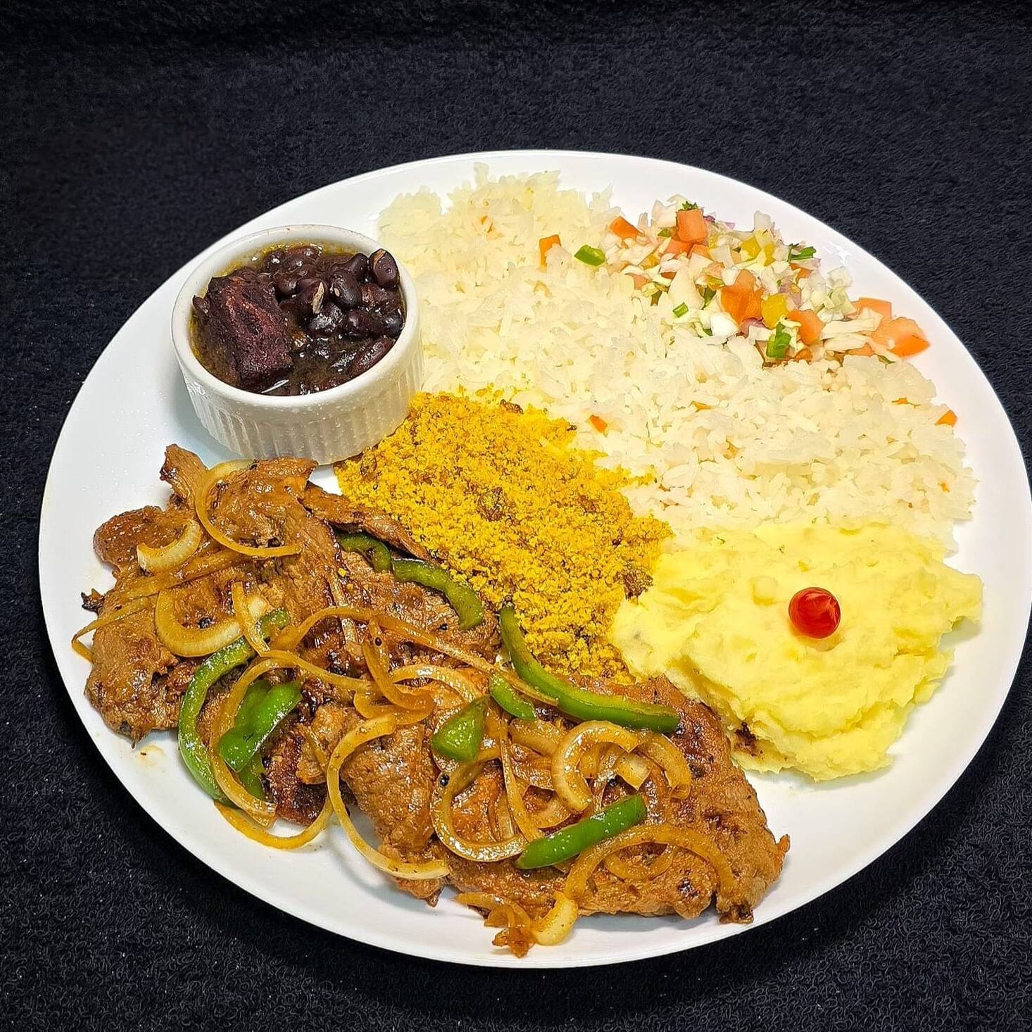 Deliciosos pedaços de Carne Especial fritos e acebolados (230g), acompanhados com arroz temperado caseiro, feijoada especial, farofa super crocante, purê de batata e vinagrete.