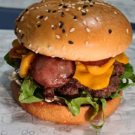 Pão com gergelim, hamburguer artesanal 120g cheddar, cremoso, 3x calabresa ,bacon,alface, tomate e cebola.