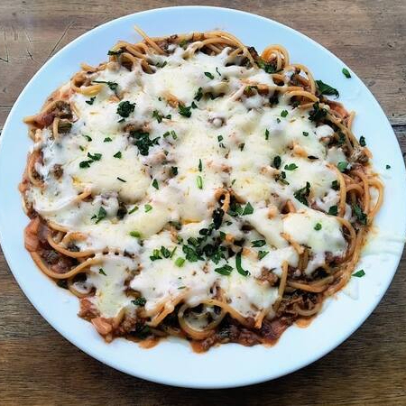 Um delicioso espaguete com molho a bolonhesa e coberto com mussarela gratinada.