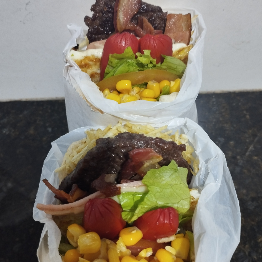 Pra duas pessoas, Lanche de Hambúrguer Bovino acompanhado de Mussarela, Apresuntado, Bacon, Salsicha, Ovo, Tomate, Alface, Milho e Batata Palha,