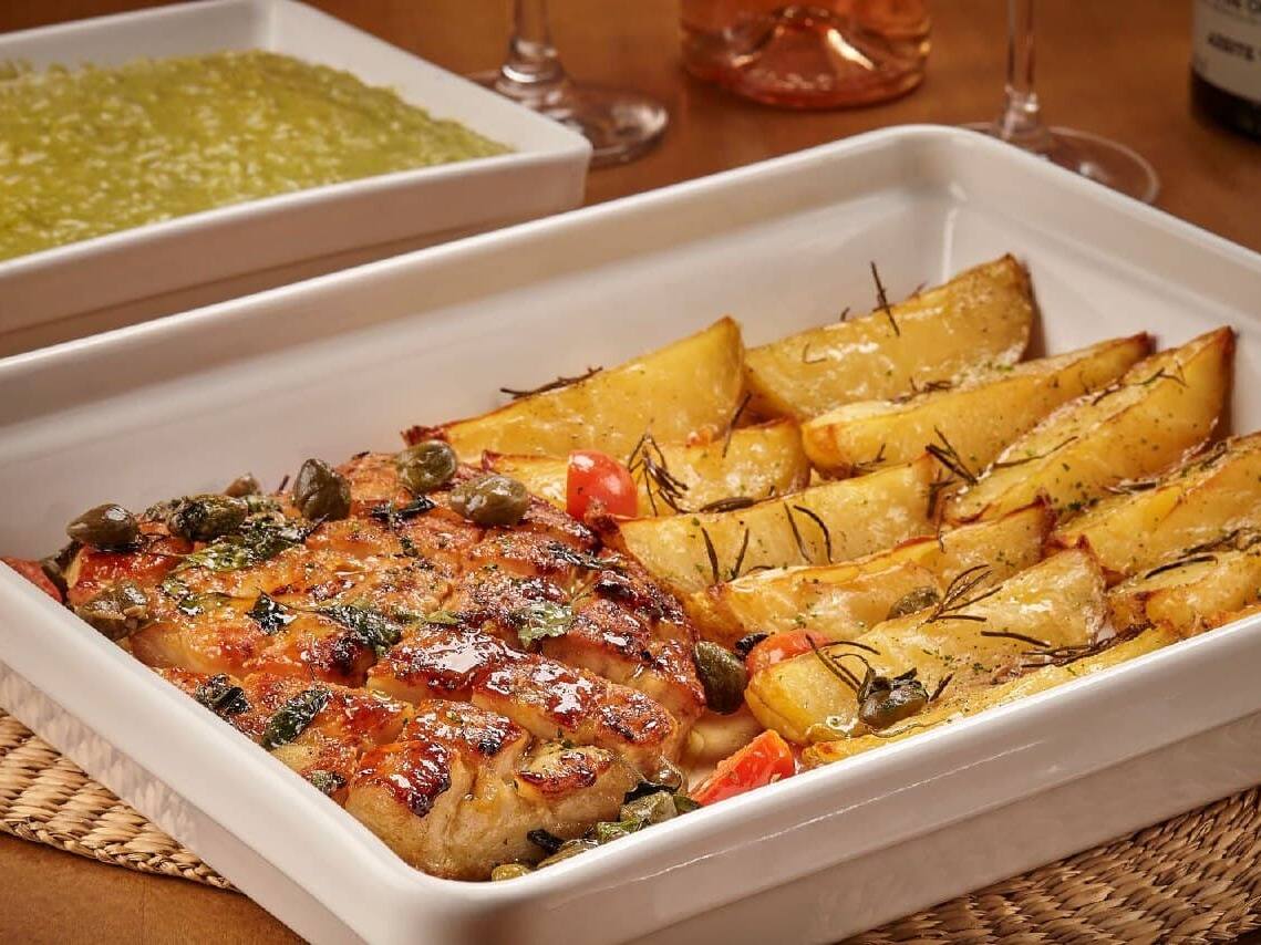 Filé de peixe ao forno com leve molho amanteigado de tomates cerejas, alcaparras, vinho branco e manjericão. Acompanha batatas ao forno e arroz cremoso compesto de manjericão