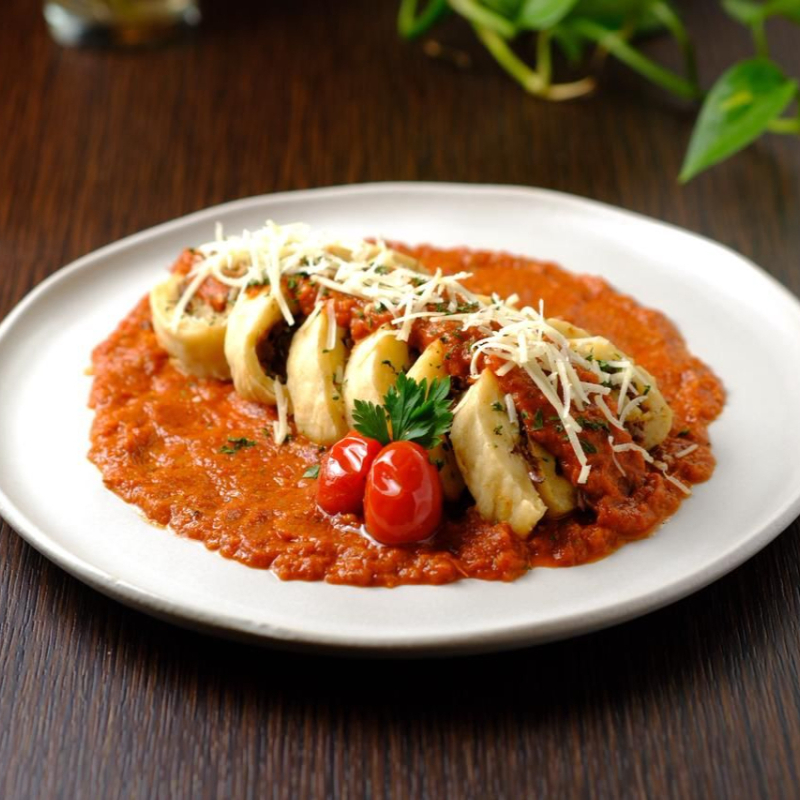 Rondelli de batata inglesa com carne de panela desfiada e molho de tomate.