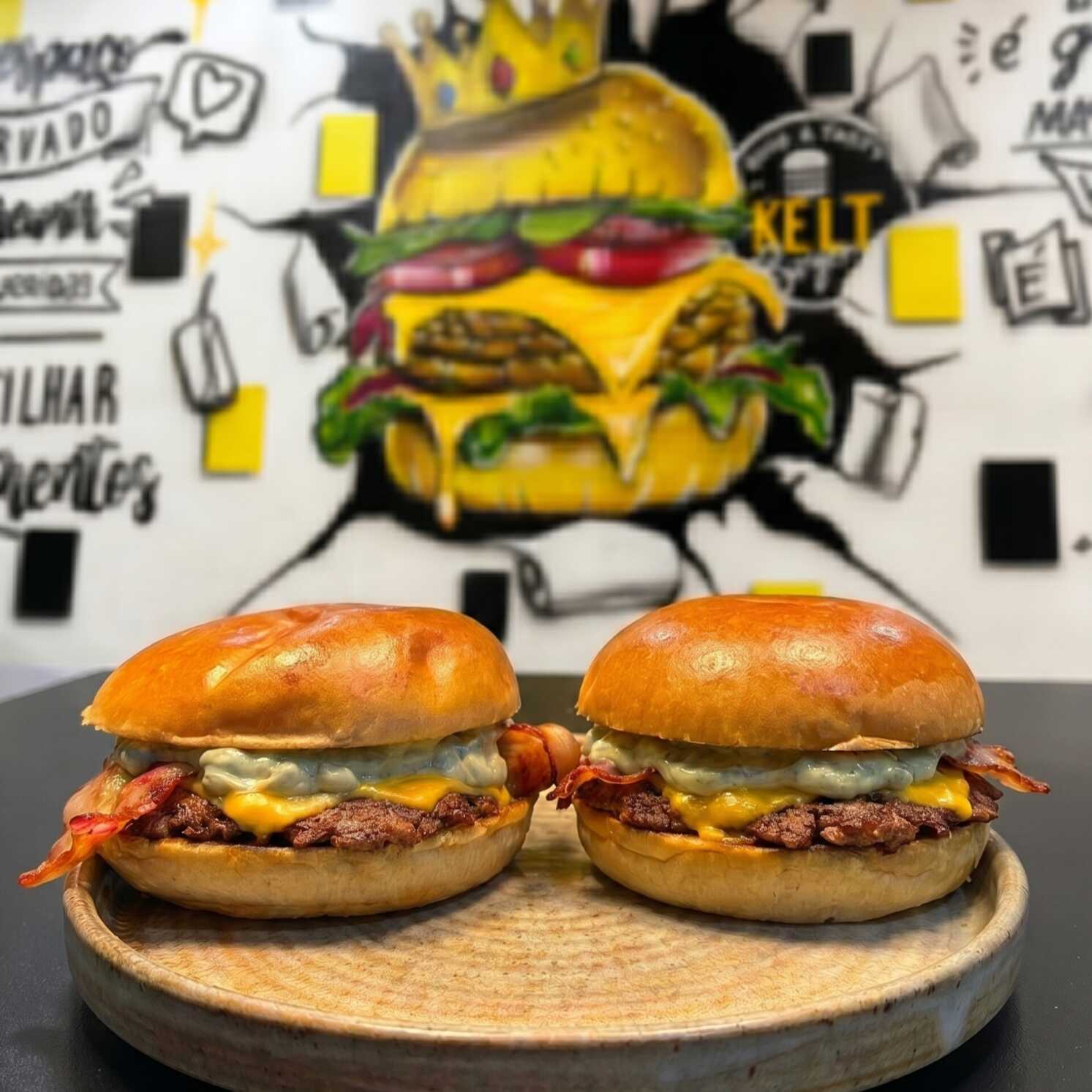 O simples bem Feito! Dois Burgers Cheddar Bacon – Dois hambúrgueres preparados no pão top, com carne de 90g, cheddar fatiado, bacon crocante e o toque especial da nossa famosa maionese verde da casa.
