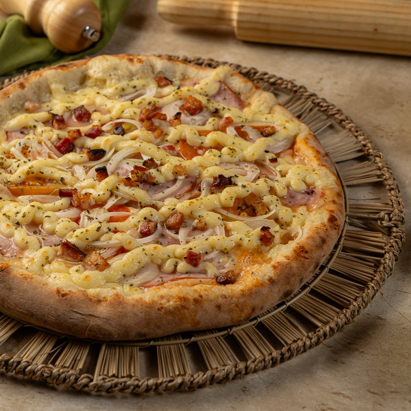Na pizza Lombo canadense vai: Molho de tomate, queijo ralado mussarela, lombo canadense, requeijão cremoso, tomate, Cebola, bacon, e orégano