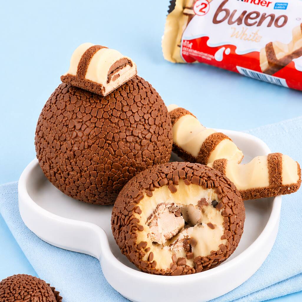 Brigadeiro gigante com recheio cremoso de Ninho e um delicioso Kinder Bueno White no centro, coberto com granulado gourmet.