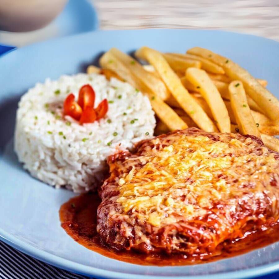 Delicioso bife de contra filé empanado, crocante e suculento com mussarela derretida e molho da casa, arroz, salada e fritas.