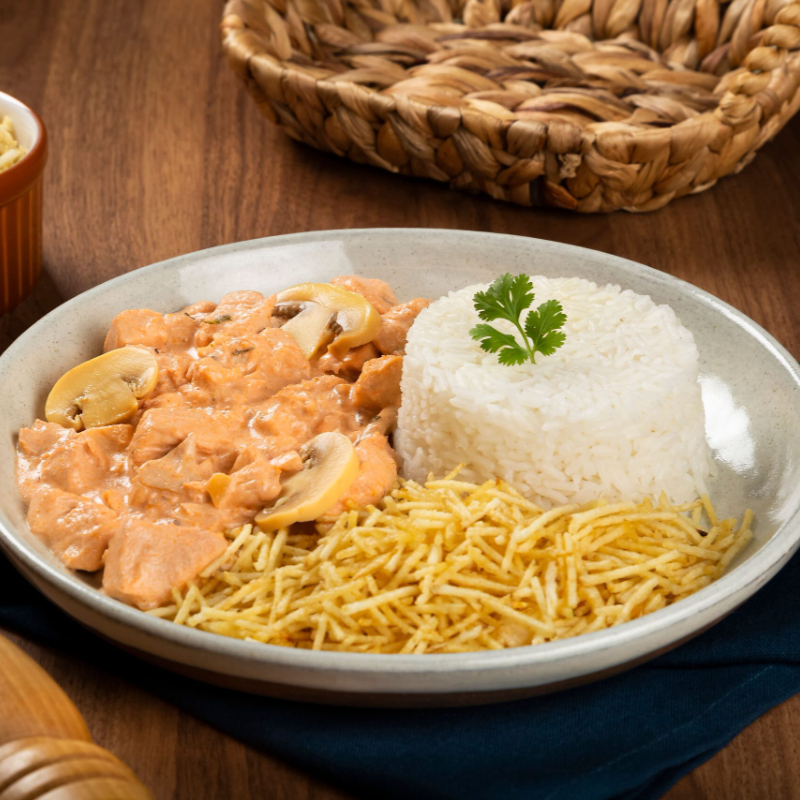 Estrogonofe de frango cremoso , servido com arroz e batata palha crocante.