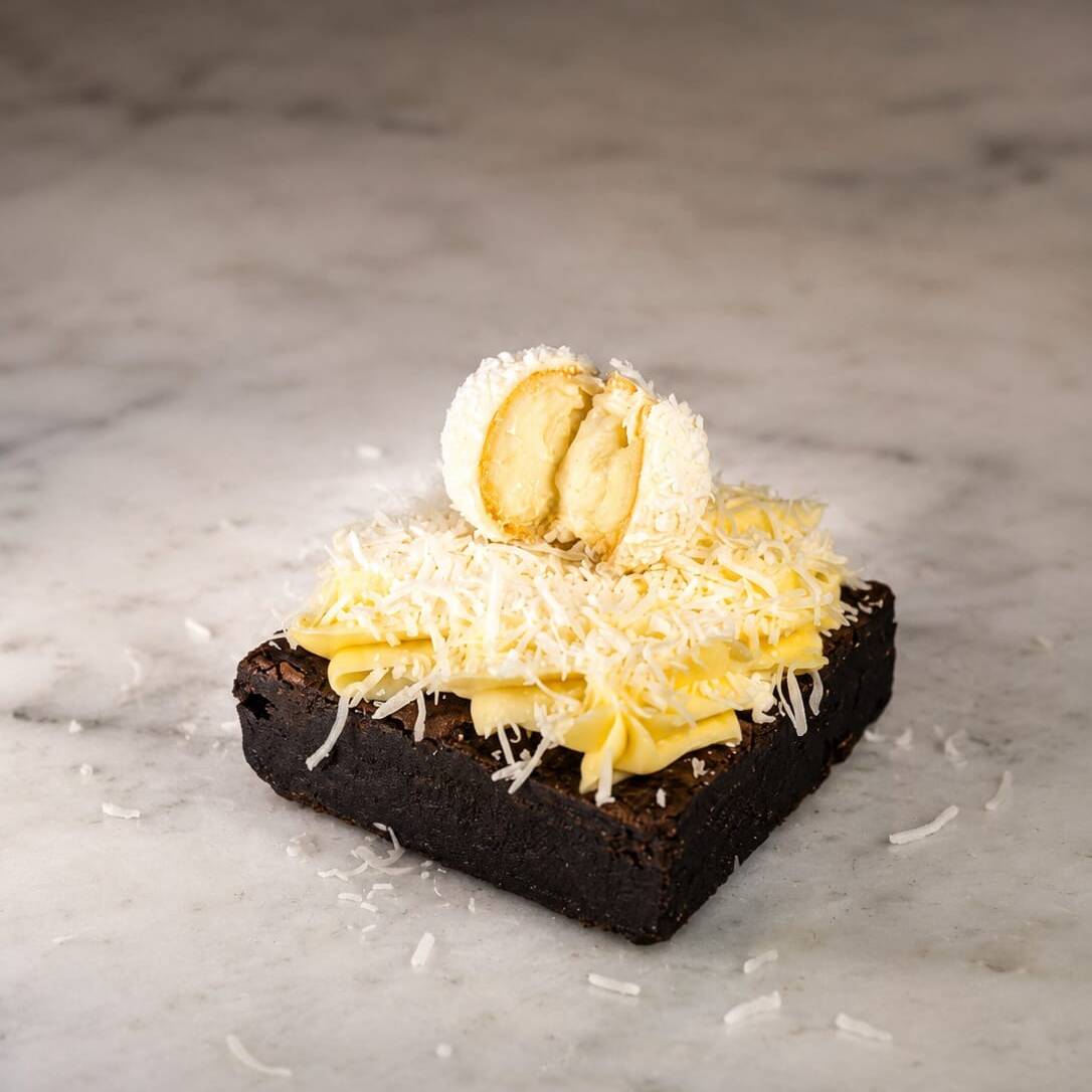 Brownie com um delicioso creme de leite ninho, uma camada de coco ralado e um Rafaello em cima.