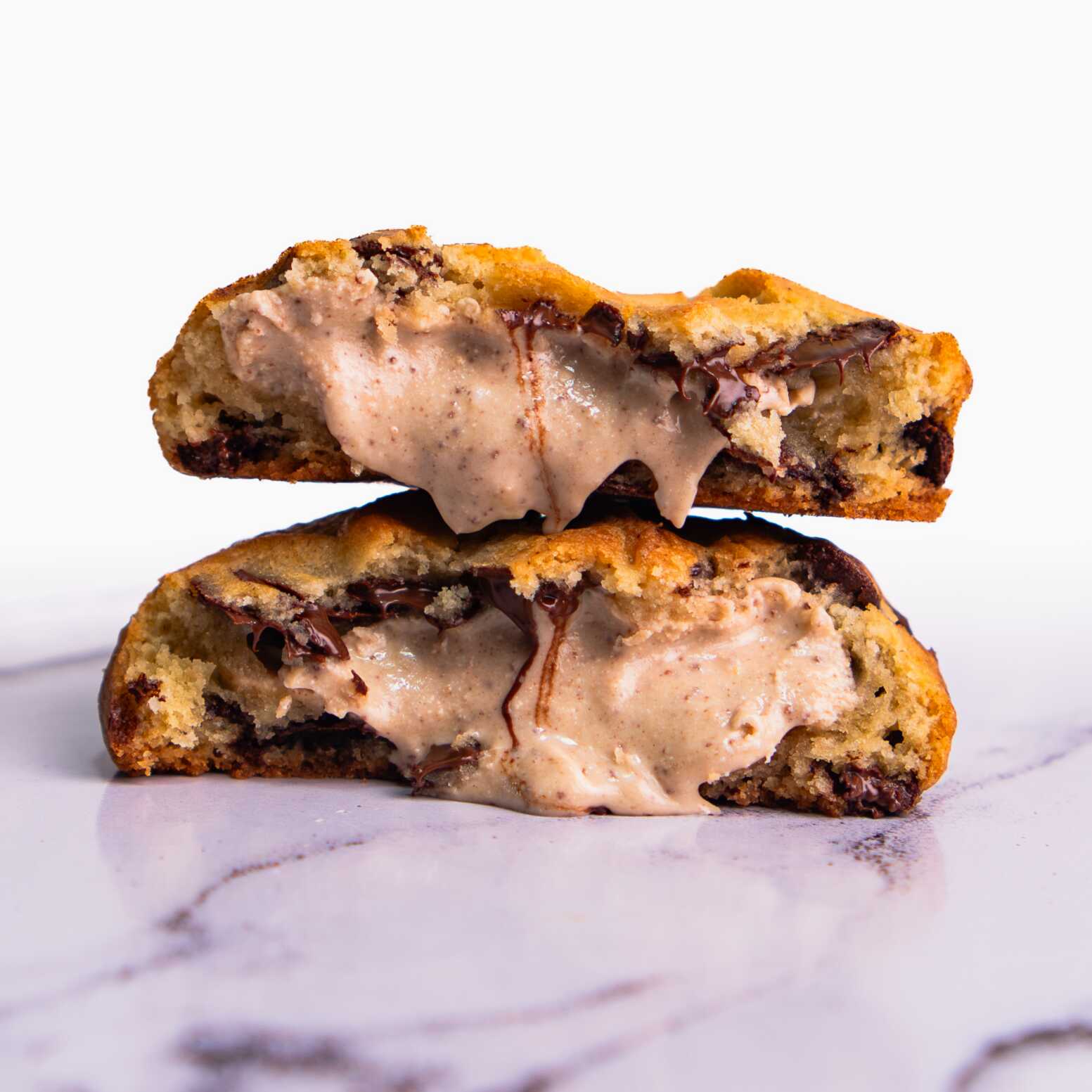 Nosso cookie de Kinder Bueno é feito com massa tradicional e gotas de chocolate nobre meio amargo. Recheado com creme de Kinder Bueno artesanal.