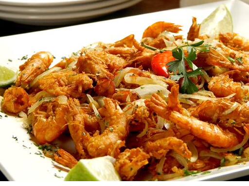 Camarões inteiros com casca marinados na cerveja, fritos e refogados com cebola e alho