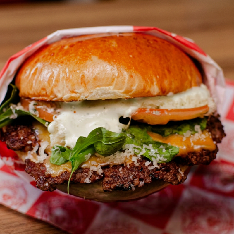 Nosso irresistível smash burger de 80g, com uma crostinha dourada e deliciosa, coberto por um cremoso american cheese, rúcula fresca, fatias de tomate, molho pesto aromático, parmesão ralado e a maionese especial da casa. Uma explosão de sabores!