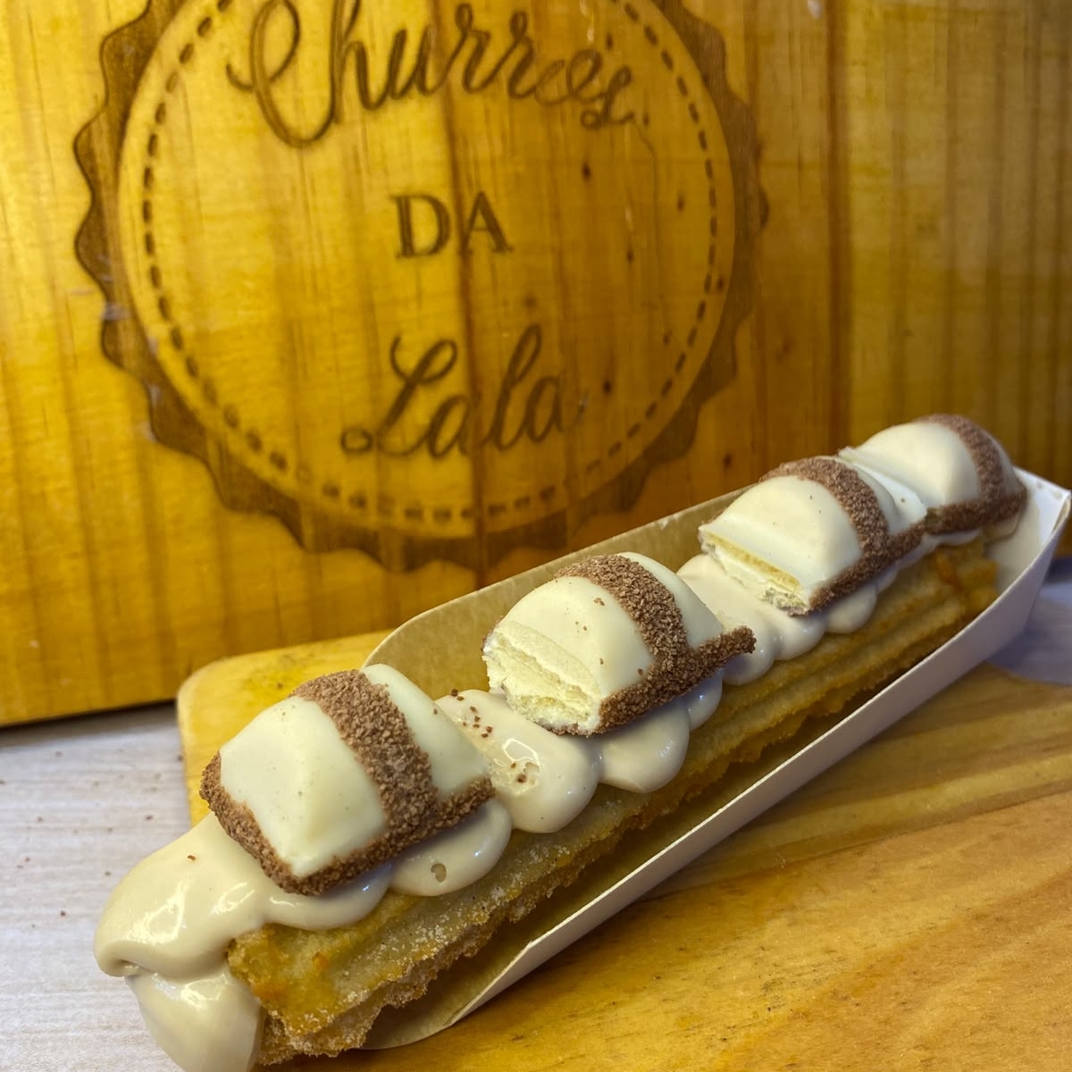 massa fresca, artesanal, feita todos os dias, bem fritinho e crocante, envolvido em açúcar e canela, com um delicioso recheio de creme bueno, finalizado com leite em pó e bombons de kinder bueno.