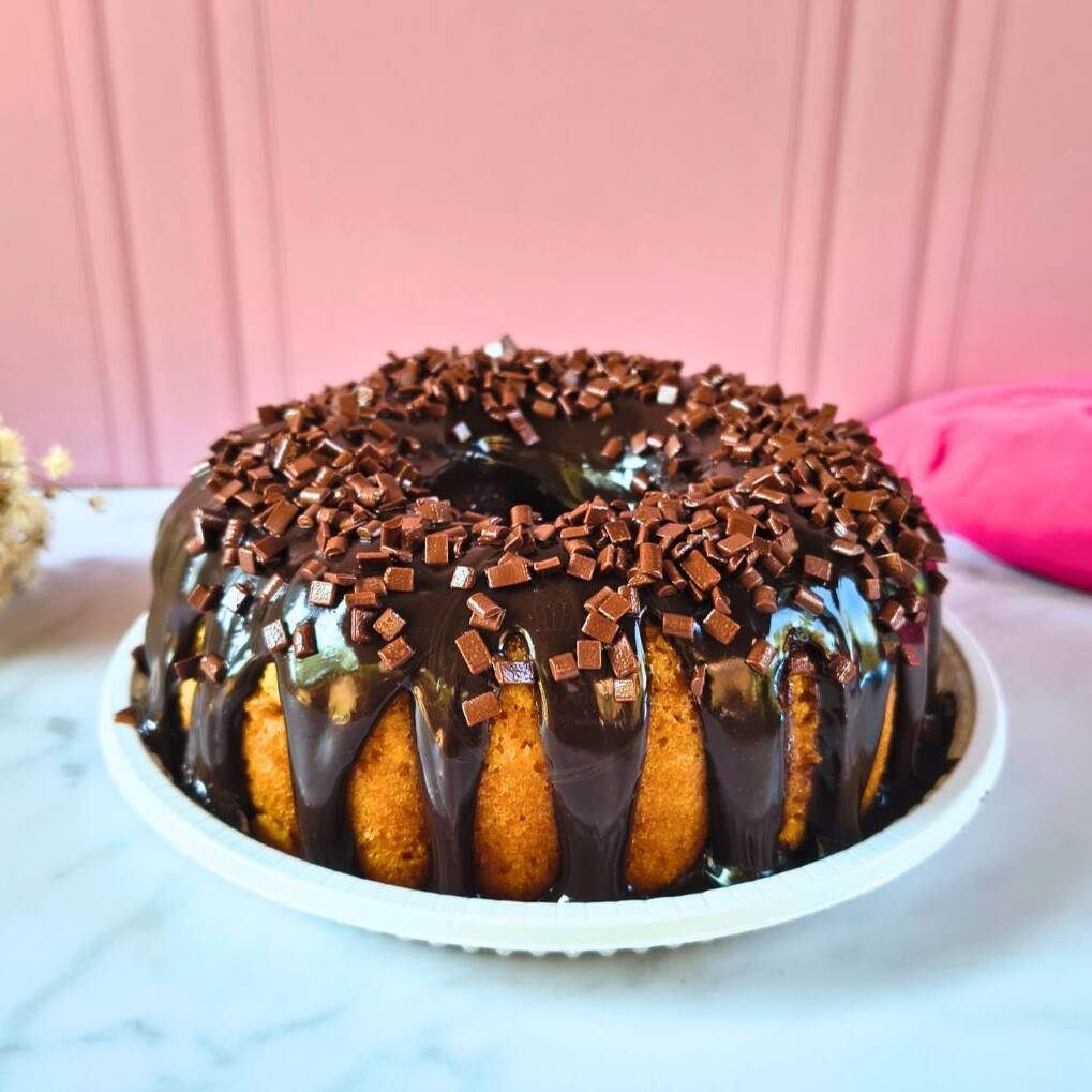 Um delicioso bolo de cenoura com essa cobertura de chocolate 50% cacau, que enche a boca d'água, uma massa fofinha e gostosa. Finalizado com Granulé Melken, confeito de chocolate puro! Serve de 4 a 6 pessoas, dependendo do corte. Peso aprox. 700g.