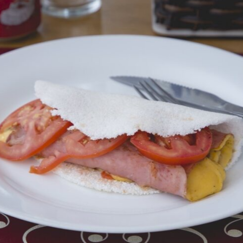 Tapioca macia e leve, recheada com queijo prato derretido, presunto de qualidade e tomate fresco, formando a combinação clássica e irresistível do tradicional Bauru.